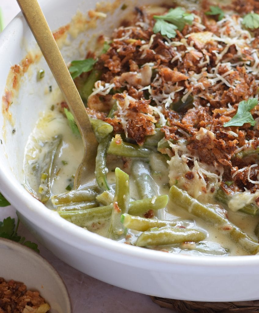 Close up of a green bean casserole in a white dish.