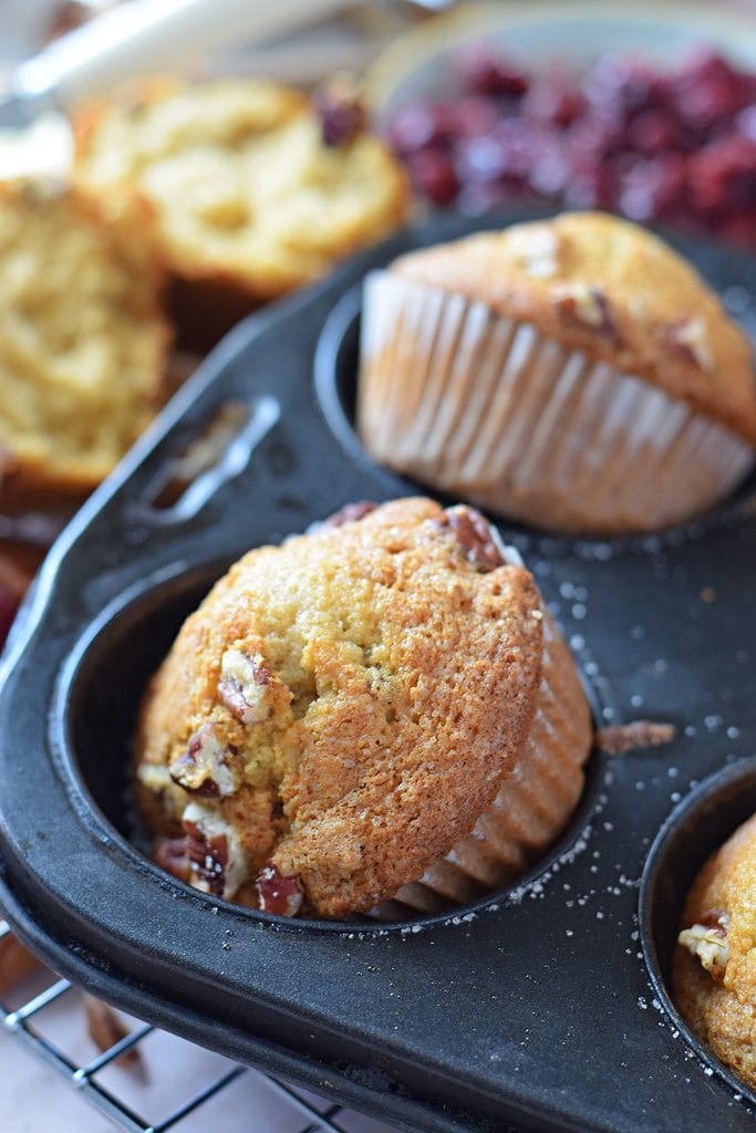 Close up of cranberry pecan muffins in a muffin tray.