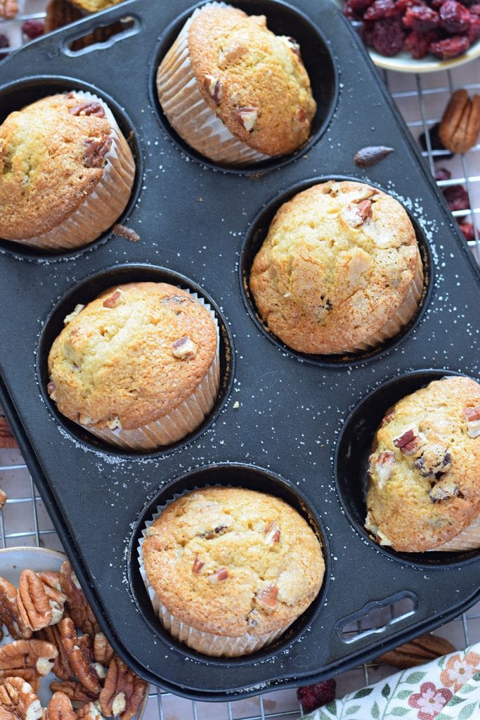 Pecan muffins with cranberries in a muffin tin.