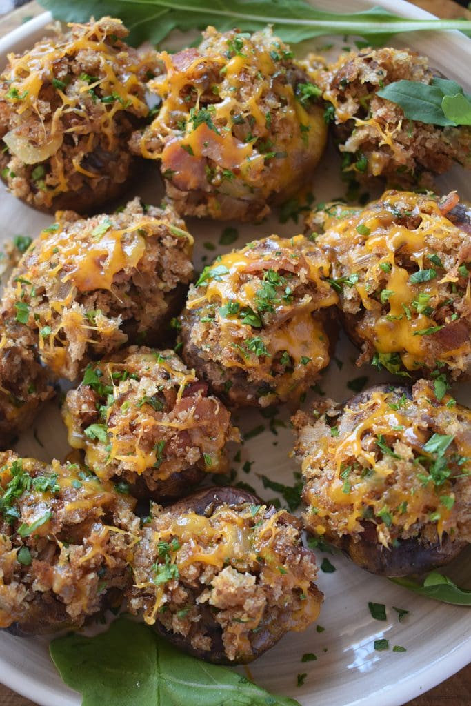 Stuffed mushrooms with cheddar cheese on a plate.