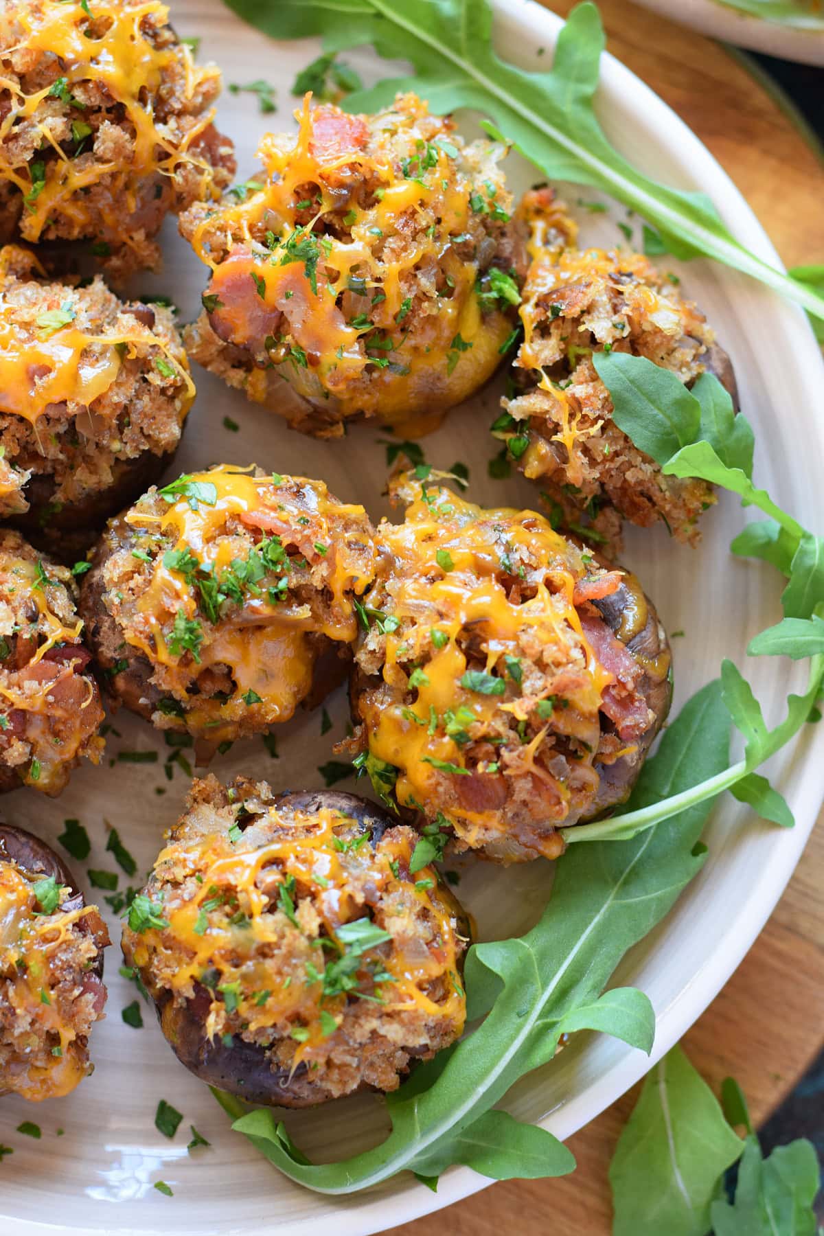 Close up of bacon and cheddar stuffed mushrooms on a plate.