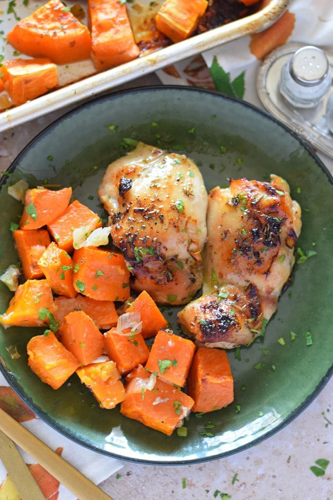 Sweet potatoes and chicken on a green plate.