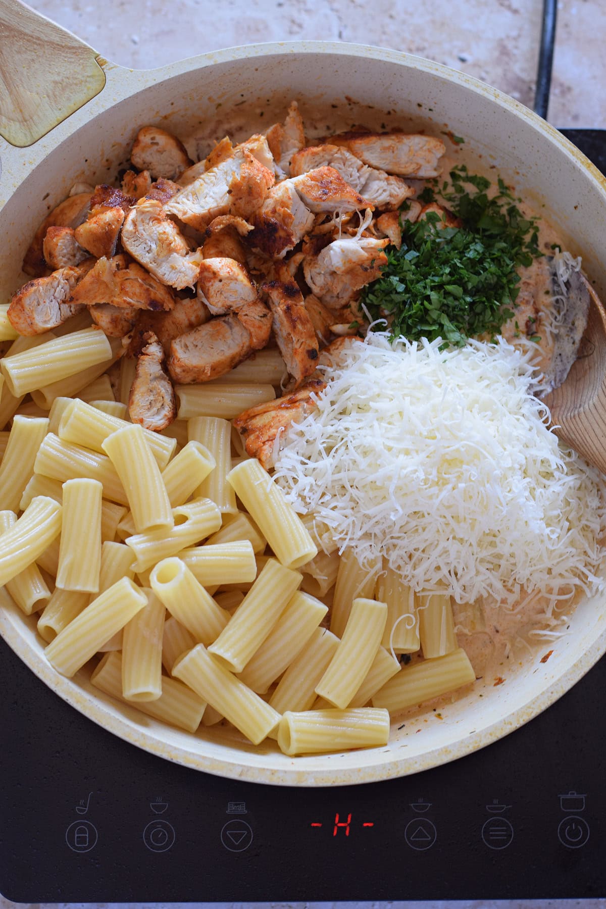 Adding pasta and chicken to a skillet.