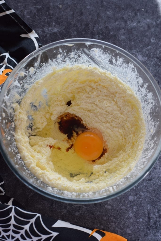Adding eggs to cookie dough.