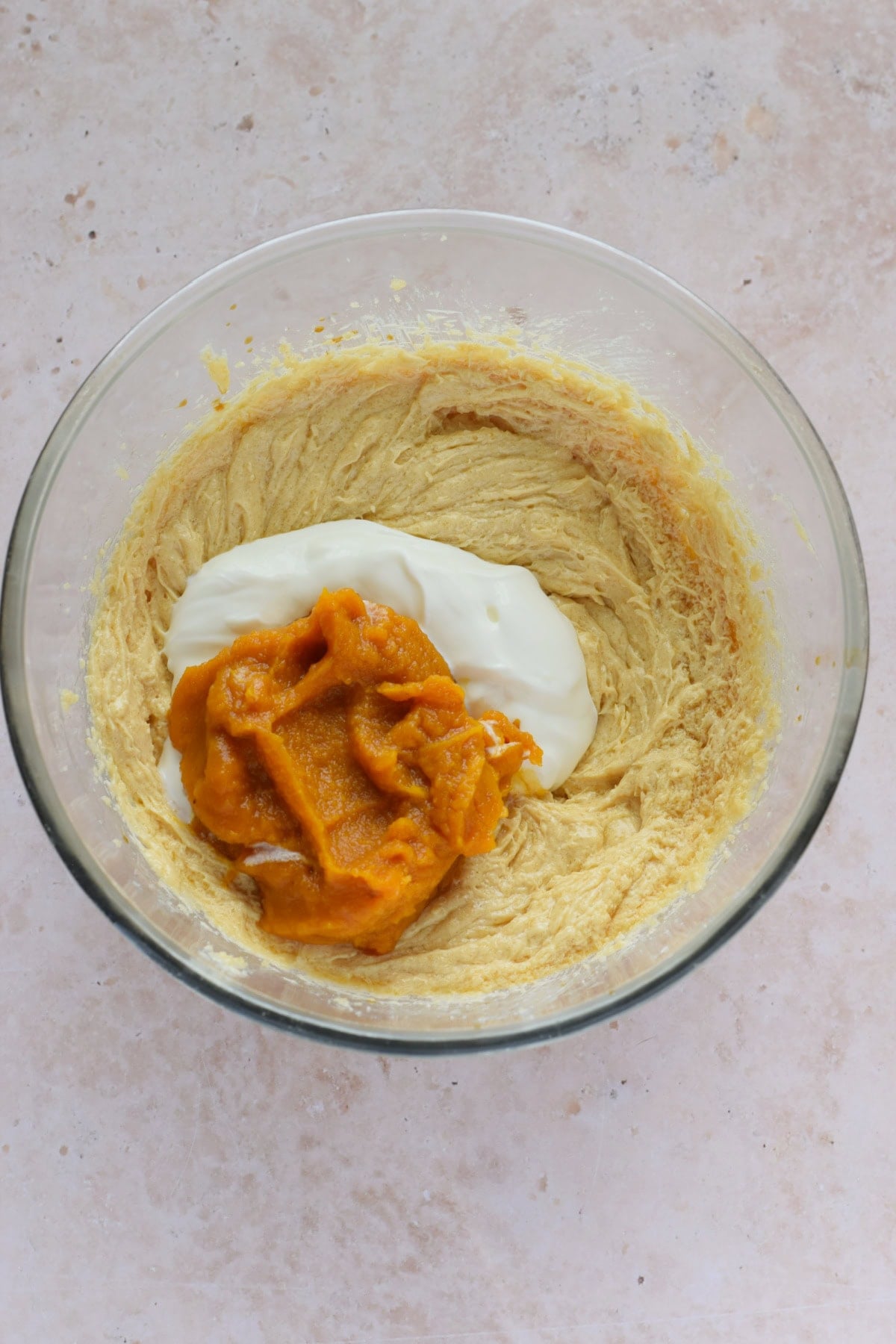 Adding Greek yogurt and pumpkin puree to muffin batter.