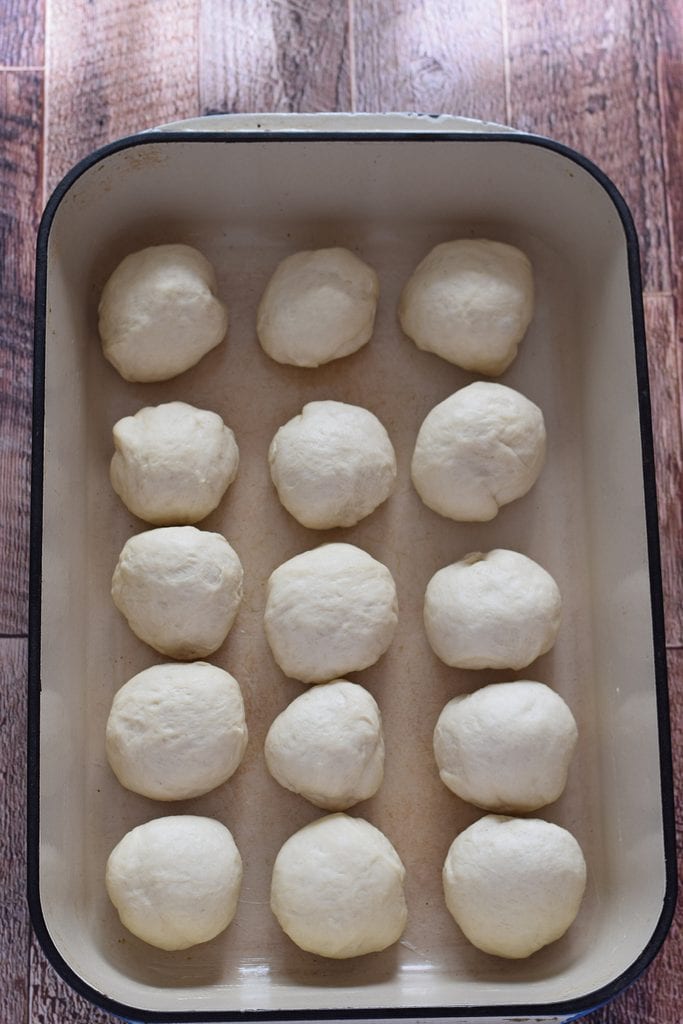Bread dough rolled in balls in a baking dish.