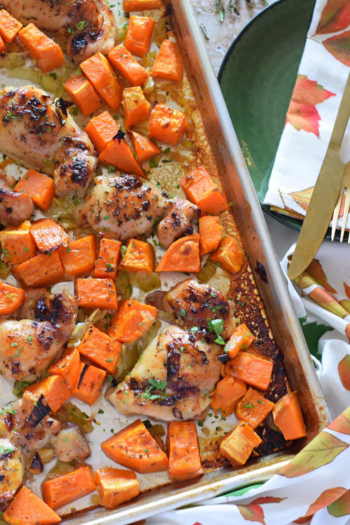 Sheet pan chicken dinner on a baking tray.