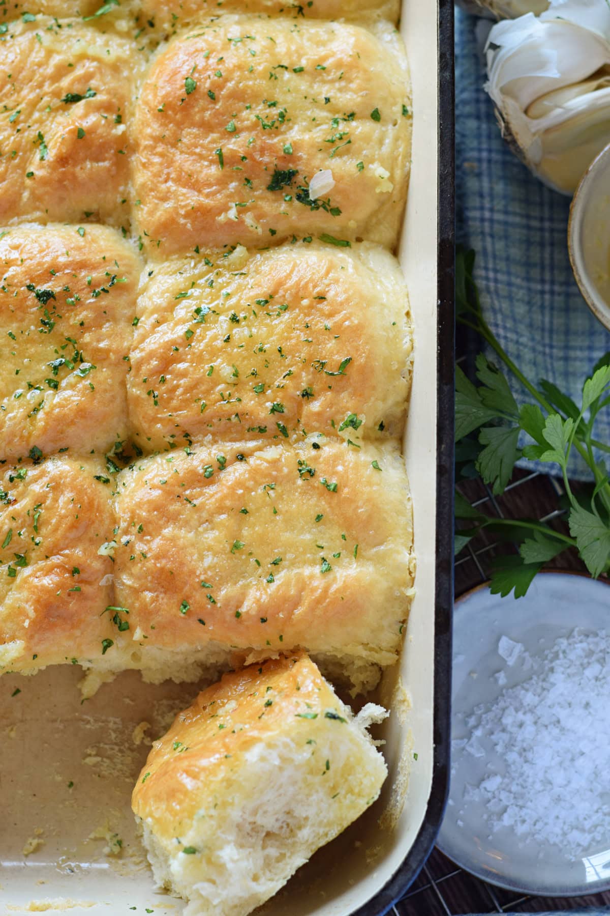 Close up of garlic butter dinner rolls in a baking dish.