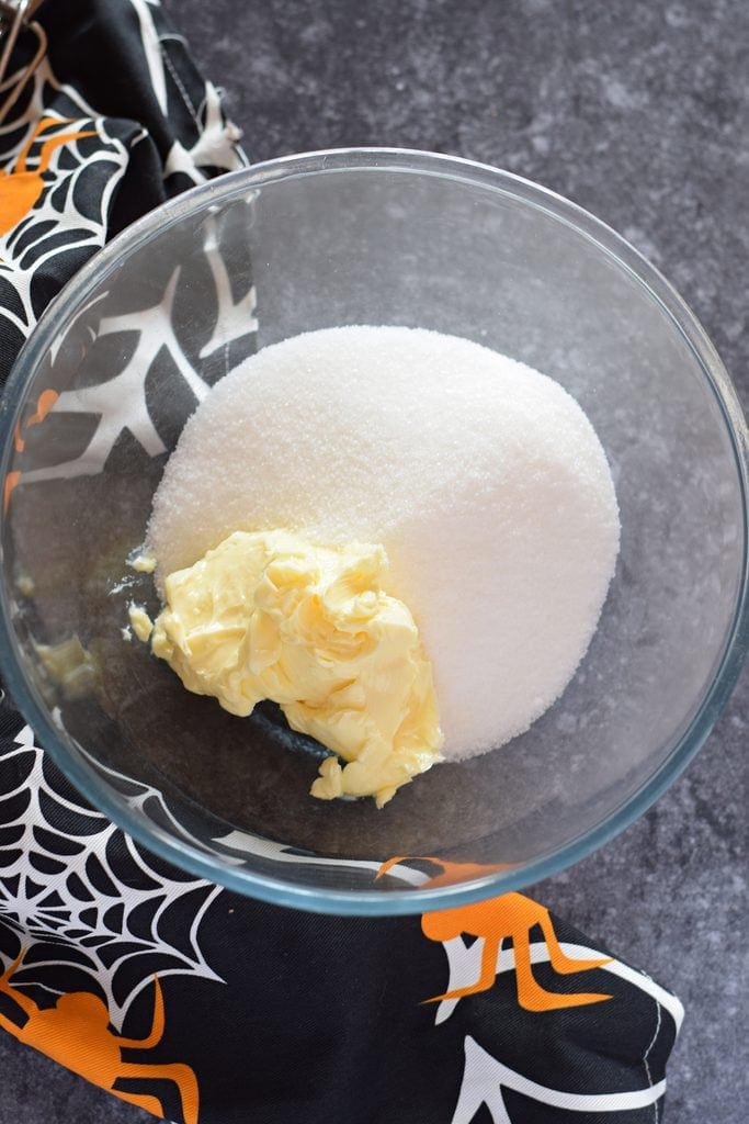 Butter and sugar in a glass bowl.