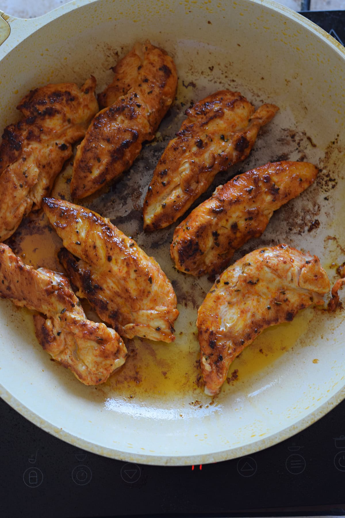 Cooking chicken tenders in a skillet.