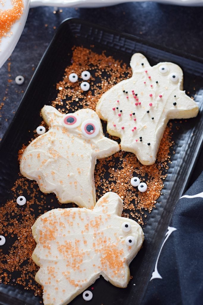 Ghost cookies on a black plate.