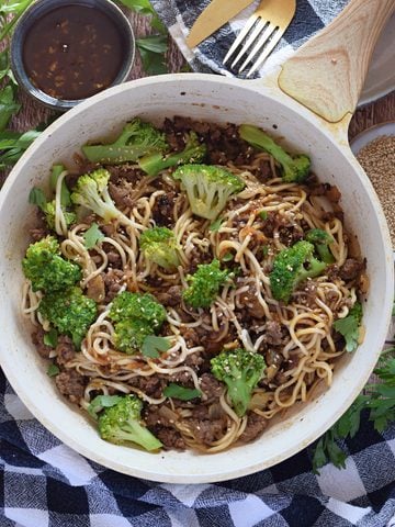 Ground beef stir fry in a white skillet.