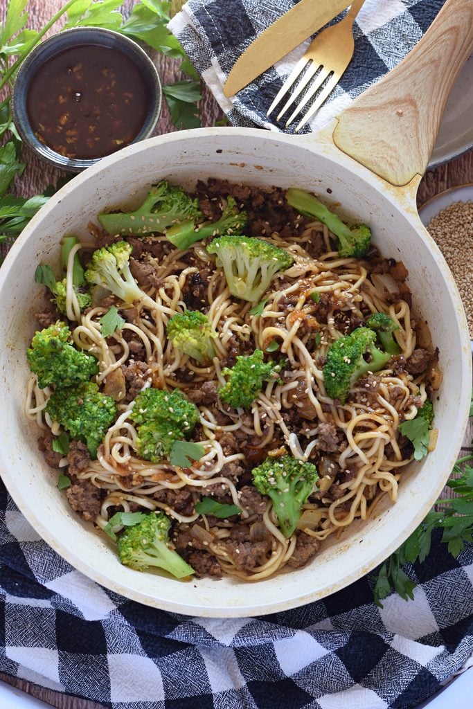 Ground beef stir fry in a white skillet.