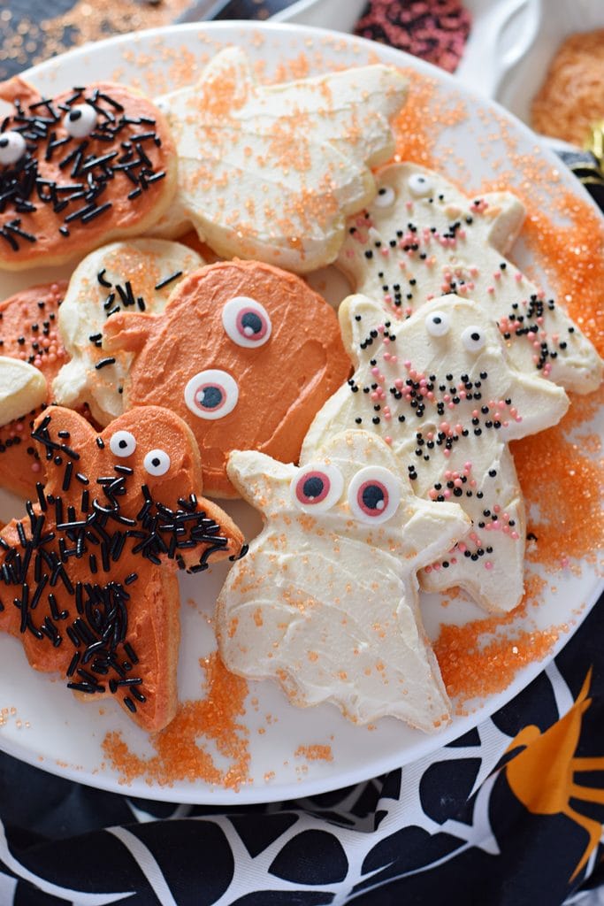 Frosted halloween cookies on a white plate.