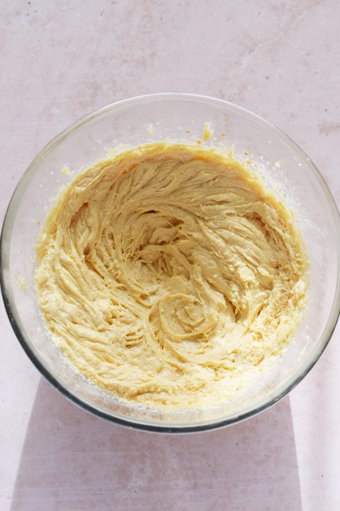 Mixing muffin batter in a glass bowl.