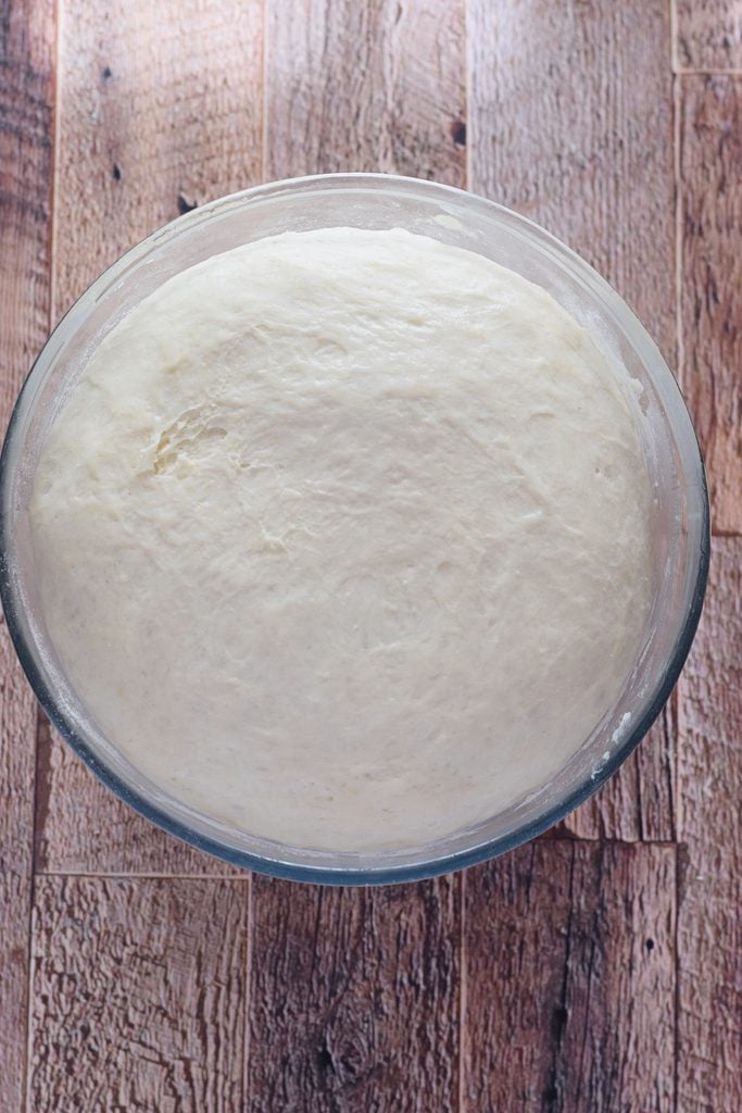 Bread dough in a glass bowl.